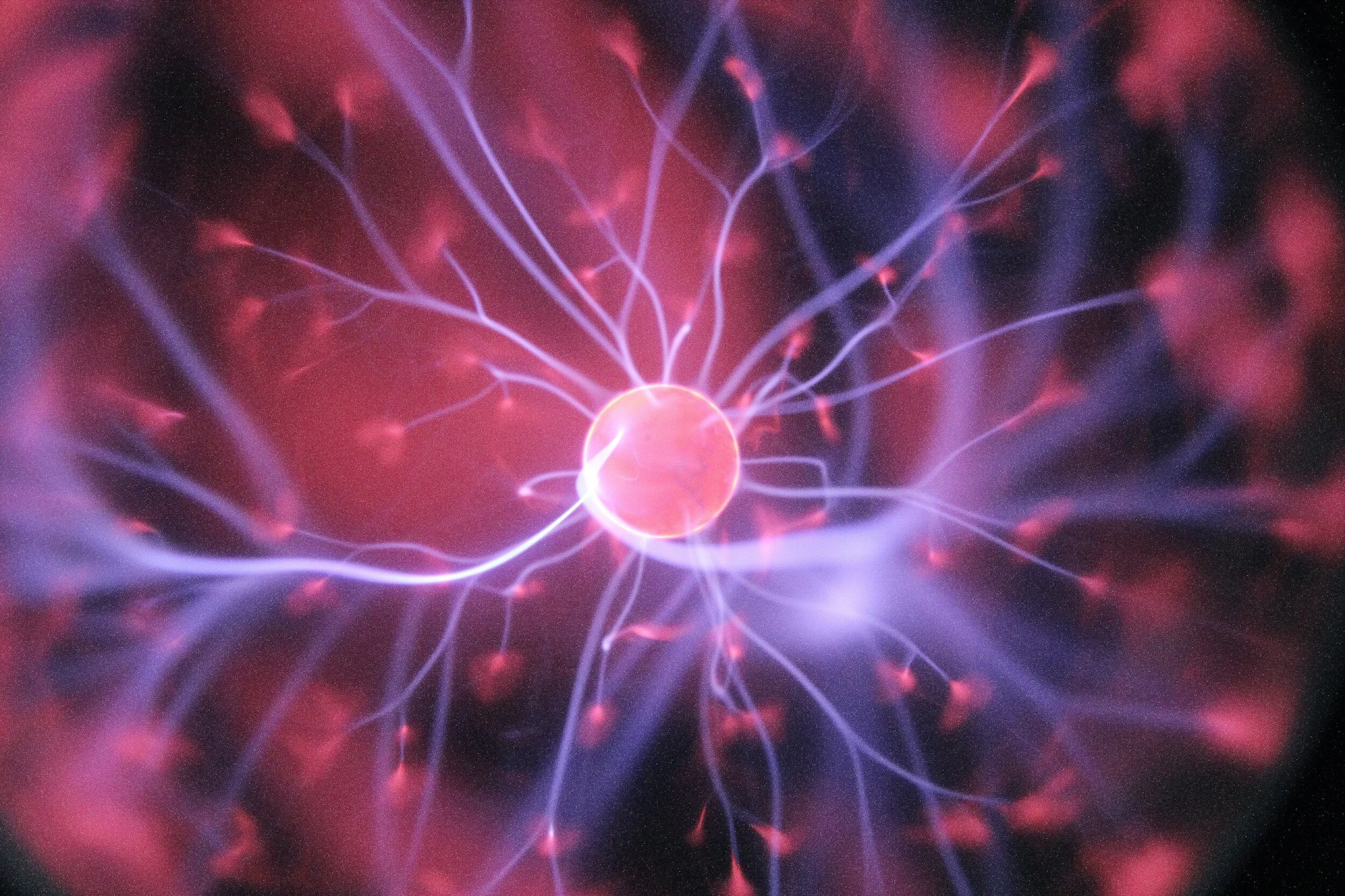 Um close-up de um neurônio com faíscas elétricas e filamentos saindo dele, representando sinapses.